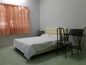 a bedroom with a bed and a chair and a window at Aplus Homestay Kluang A嘉民宿 in Kluang