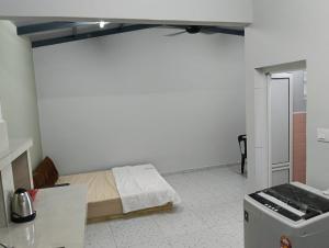 a bedroom with a bed in a room with a refrigerator at Aplus two rooms in Kluang +17 photos