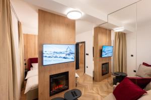 salon z kominkiem i telewizorem na ścianie w obiekcie Apartman G1 w mieście Pale
