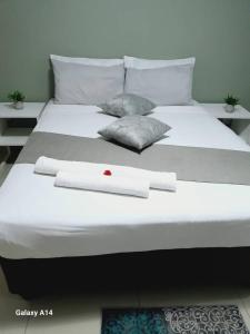 een groot wit bed met handdoeken en kussens erop bij Thukhana House in Maun