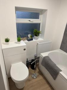 a bathroom with a toilet and a sink and a window at 25 Birks Road in Cleator Moor