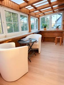 Cette chambre comprend des chaises blanches, une table et des fenêtres. dans l'établissement Fichtenblick, à Selb