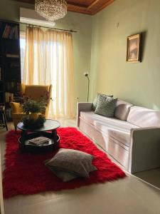 a living room with a couch and a red rug at Sirius in Igoumenitsa