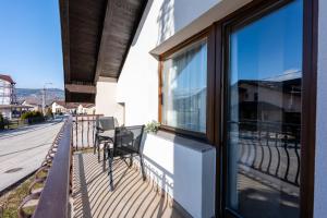 balkon ze stołem i krzesłami na budynku w obiekcie Apartman G1 w mieście Pale