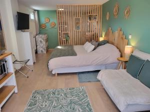 ein Wohnzimmer mit zwei Betten und einem Fernseher in der Unterkunft Le gite du seigle in Montferrat