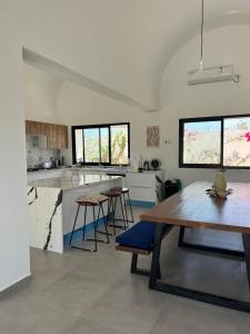 a kitchen with a wooden table and a dining room at Maison Ile d'Olive in Midoun
