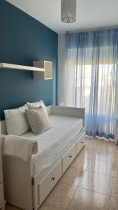 une chambre avec un lit aux murs bleus et une fenêtre dans l'établissement Casa Gisbert Centro histórico Parking Free, à Carthagène