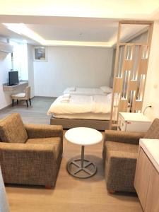 une chambre avec un lit, un canapé et une table dans l'établissement Royal Garden Home Hotel, à Bangkok