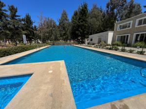 een groot blauw zwembad voor een gebouw bij Cómodo Depto en bosques de la candelaria in Algarrobo