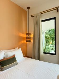 a bedroom with a white bed and a window at Casa Zala in El Paredón Buena Vista
