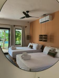 two beds in a room with a mirror at Casa Zala in El Paredón Buena Vista