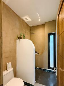 a bathroom with a white toilet and a window at Casa Zala in El Paredón Buena Vista