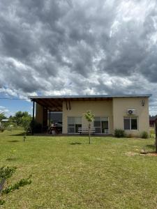 een huis met een bewolkte lucht in een tuin bij Complejo Aires del Cielo in San José