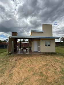 een klein huis met een patio in een veld bij Complejo Aires del Cielo in San José +15 foto's