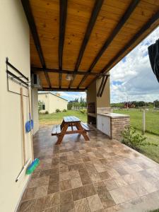 een terras met een houten plafond en een picknicktafel bij Complejo Aires del Cielo in San José +15 foto's