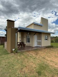 een huis met een picknicktafel ervoor bij Complejo Aires del Cielo in San José