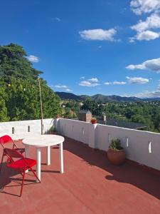 a white table and a red chair on a roof at Cielo Serrano VCP in Villa Carlos Paz