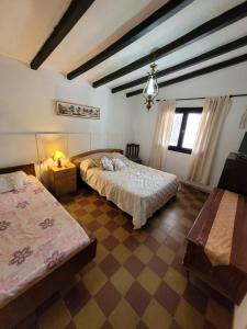 a bedroom with two beds and a lamp in it at Casa Paraiso Serrano in Valle Hermoso +3 photos
