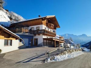 a house in the mountains with snow on the ground at Appartement Gsaller in Hopfgarten in Defereggen