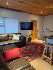 a living room with a couch and a flat screen tv at Governor's nest in Cape Town
