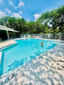 a person swimming in a large swimming pool at Blue Skies Seaside Veranda in New Smyrna Beach +22 photos