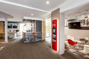 a red coke machine in a room with a kitchen at ibis Lannion in Lannion