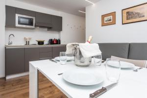a kitchen with a white table with plates and glasses at Ski Gate - Main Street by Cervino View Experience in Breuil-Cervinia