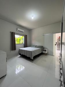 een witte slaapkamer met een bed en een raam bij Alphaville Pousada e Hostel in Bonito