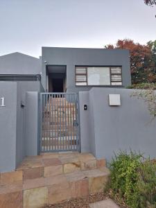 a gray house with a gate and stairs at Governor's nest in Cape Town