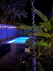 een kerstverlichtingsmast naast een zwembad 's nachts bij Raya in Matapalo