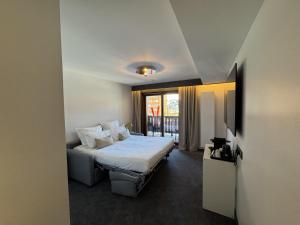 ein Hotelzimmer mit einem Bett und einem Fenster in der Unterkunft PopAlp la Plagne - Hôtel et Restaurant in La Plagne Tarentaise