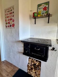 a stove in the corner of a kitchen with a pile of wood at Holiday Home Skoaffär in Lakene