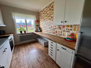 a kitchen with white cabinets and a wooden floor at Holiday Home Skoaffär in Lakene
