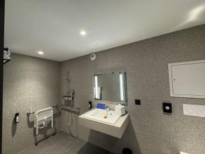 ein Badezimmer mit Waschbecken und Spiegel in der Unterkunft PopAlp la Plagne - Hôtel et Restaurant in La Plagne Tarentaise