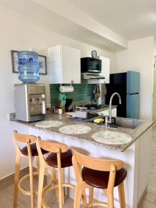 - une cuisine avec 2 chaises et un comptoir dans l'établissement Escapada frente al mar, Piscinas y los Mejores Atardeceres -Playa Caracol-, à El Quindio