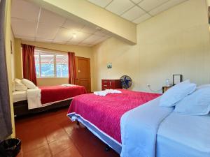 een slaapkamer met twee bedden en een raam bij Casa de Alondras in Panajachel