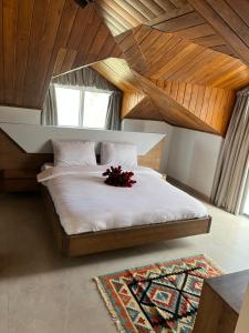 een slaapkamer met een wit bed met bloemen erop bij Terminal K Bhamdoun Hotel in Aley