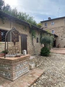 a stone house with a stone fountain in the yard at BORGO VILLA VALENTINI in Scandiano