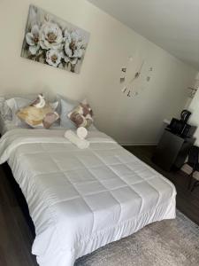 una camera da letto con un letto bianco e un orologio a parete di La Aurelia Resort a Lowlands