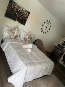 una camera da letto con un letto bianco e un orologio a parete di La Aurelia Resort a Lowlands