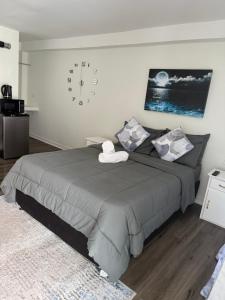 una camera da letto con un grande letto con un orologio sul muro di La Aurelia Resort a Lowlands