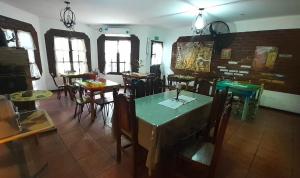 a dining room with tables and chairs and windows at maemm el castillto in Mina Clavero
