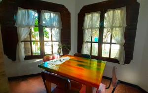 a dining room with a wooden table and two windows at maemm el castillto in Mina Clavero +36 photos