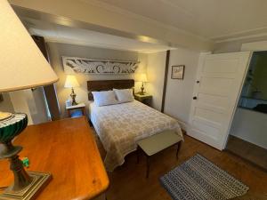 een slaapkamer met een bed en een tafel met een lamp bij Hawks House Inn in Walpole