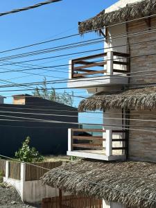 a building with a thatch roof and a balcony at Preá Beach Flat in Cruz