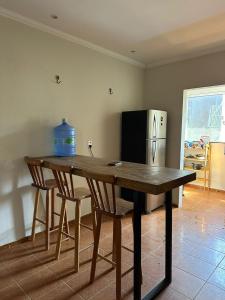 a kitchen with a wooden table with chairs and a refrigerator at Preá Beach Flat in Cruz
