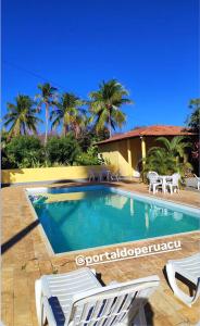 una piscina con due sedie a sdraio e palme di Pousada Portal do Peruaçu a Januária Altre 18 foto