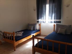 twee bedden in een kamer met een raam bij Seaside studio with swimming pool & parking #2 in Kassandria