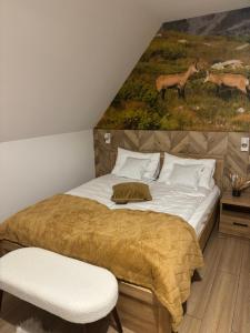 a bedroom with a bed with a painting on the wall at Rusiński Raj - Domki in Bukowina Tatrzańska
