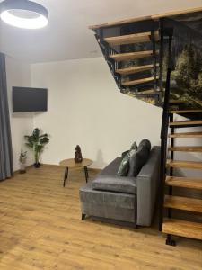 een woonkamer met een bank en een wenteltrap bij Rusiński Raj - Domki in Bukowina Tatrzańska